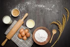 Top view of ingredients bakery making on black wooden table photo