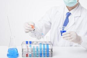 close up of cientist is testing and researching some blue liquid chemical in laboratory isolated white background. photo