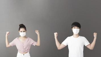 Portrait of man and woman with surgical mask  in studio, social distancing  concept photo