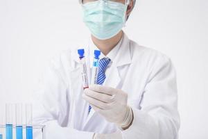 close up of cientist is testing and researching some blue liquid chemical in laboratory isolated white background. photo