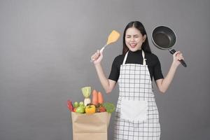 mujer feliz está preparando comida saludable para cocinar foto