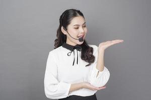 retrato de una hermosa mujer operadora de fondo gris foto