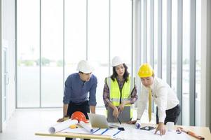 los ingenieros son planes de construcción analíticos con planos en la oficina foto