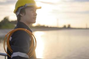 A male engineer wearing a protective helmet at sunset. photo