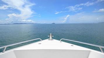 A view of front luxury speedboat with a beautiful ocean and mountain in background photo