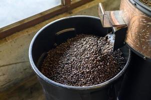 Coffee beans is roasting in roaster machine in coffee shop. photo