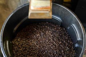 Coffee beans is roasting in roaster machine in coffee shop. photo