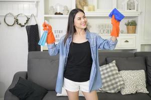 una mujer con guantes de limpieza que usa desinfectante en aerosol de alcohol para limpiar la casa, saludable y médica, concepto de protección covid-19 en el hogar foto