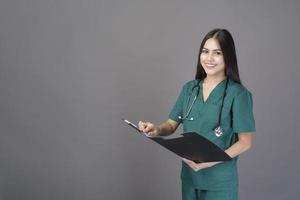 young happy beautiful woman doctor wearing a green scrubs is holding documents photo