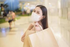 portrait of beautiful woman is wearing face mask in shopping center photo