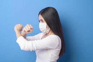 portrait of young woman is wearing face mask on Blue background photo