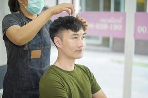 a young man is getting a haircut in a hair salon, Salon safety concept