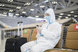 An Asian man is wearing ppe suit in International airport , Safety travel , covid-19 protection , social distancing concept