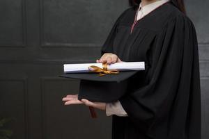 cerrar la mujer de graduación tiene gorra y certificado foto