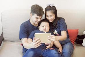 la familia feliz está disfrutando en el sofá en casa, el concepto de actividad en el hogar de seguridad foto