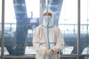 An Asian man is wearing ppe suit in airport elevator , Safety travel , covid-19 protection , social distancing concept