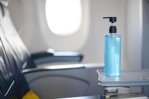el desinfectante de gel de alcohol está en la mesa de la bandeja en el avión para los pasajeros durante el vuelo