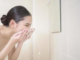 una mujer hermosa se lava la cara