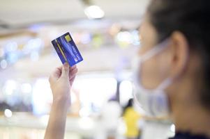 una mujer joven con máscara facial de compras en el centro comercial. foto