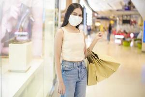 portrait of beautiful woman is wearing face mask in shopping center photo