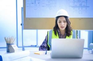 female engineer using laptop, making video call to client or business partner photo