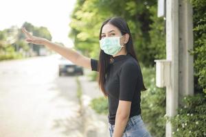 mujer joven lleva mascarilla en la ciudad al aire libre foto