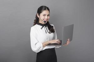 Portrait of beautiful operator woman on gray background photo