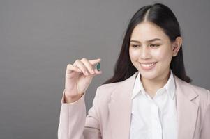 Beautiful woman in suit is taking pill photo