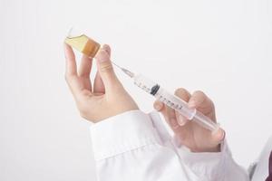 Beautiful woman doctor with hijab is holding vaccine  on white background photo