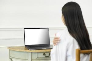 Female doctor making video call on laptop mock up screen with patient photo