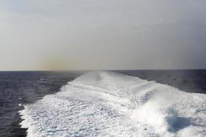 sendero en la superficie del agua detrás de un bote a motor en movimiento rápido foto