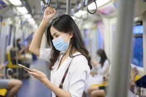 una mujer joven lleva una máscara protectora en el metro , protección covid-19 , viajes seguros , nueva normalidad , distanciamiento social , transporte seguro , viajes bajo el concepto de pandemia .