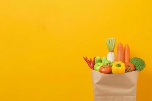 vegetables in grocery bag on yellow background photo