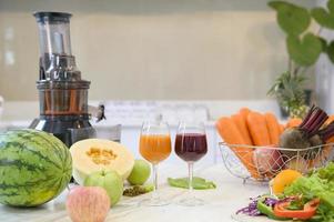 frutas frescas saludables, verduras y exprimidores están sobre la mesa en la cocina listos para ser preparados, concepto de salud foto