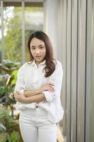 retrato de una mujer asiática de negocios confiada con camisa blanca en el cargo foto