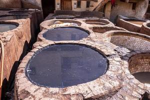 Dyed water fill in tanks in empty tannery and old building photo