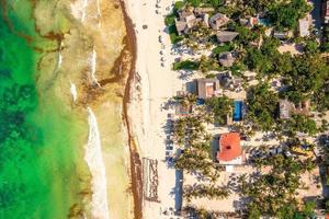 Aerial Tulum coastline by the beach with a magical Caribbean sea and small huts by the coast. photo