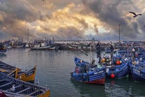 Barcos de pesca de madera anclados en el puerto deportivo contra el espectacular cielo nublado foto