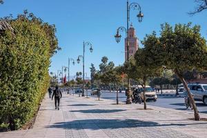 vista de peatones caminando en la calle con la mezquita koutoubia contra el cielo foto