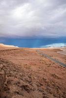 Scenic view of highway through desert against dramatic sky in summer photo