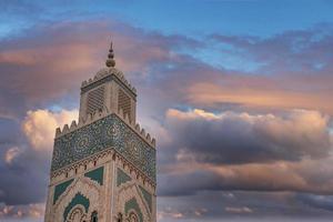 vista de ángulo bajo de la histórica mezquita hasan ii con el minarete más alto contra el cielo dramático foto