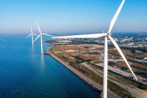 Aerial view of the wind turbines. Green ecological power energy generation. Wind farm eco field. Offshore and onshore windmill farm green energy at sea photo
