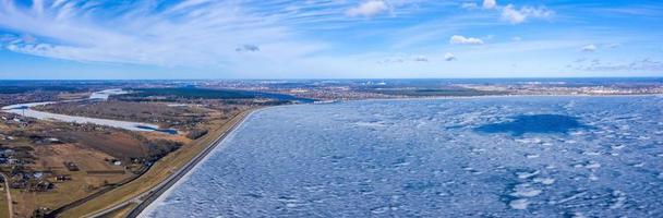 vista aérea de invierno de la enorme presa en letonia cerca de la ciudad de salaspils y riga. un enorme embalse de agua y río daugava. planta eléctrica hidroeléctrica. foto