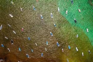 Aerial view of many sailing boats anchoring next to reef. photo