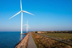 Aerial view of the wind turbines. Green ecological power energy generation. Wind farm eco field. Offshore and onshore windmill farm green energy at sea photo