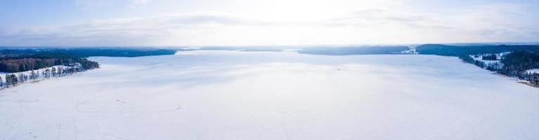 Beautiful aerial view of the huge frozen lake in the middle of a forest in Latvia. Frozen Ungurs lake in Latvia. photo