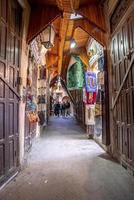 Pedestrian walking on narrow street of marketplace with closed doors photo