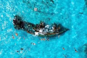 People snorkelling around the ship wreck near Bahamas in the Caribbean sea. photo
