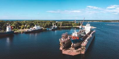 Riga, Latvia. June 10, 2021. Cargo ship at floating dry dock is being renovated photo