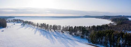 hermosa vista aérea del enorme lago congelado en medio de un bosque en letonia. lago ungurs congelado en letonia.